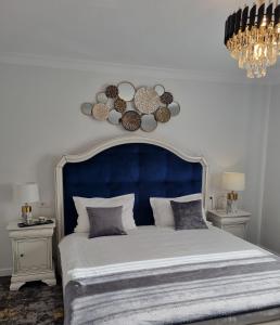 Tesa Boutique Hotel في تارجو نيمت: سرير كبير مع اللوح الأمامي الأزرق وطاولتين