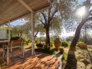 a wooden patio with a bench and a tree at Tra Gli Ulivi in Pietra Ligure