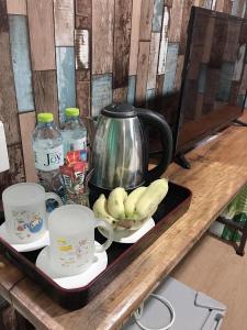 Ban Lum Fuang的住宿－Phuketnumnoi23，茶壶和香蕉盘