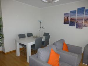 sala de estar con mesa y sofá en Algarve T2 apartment with pool and balcony in Olhão, en Olhão