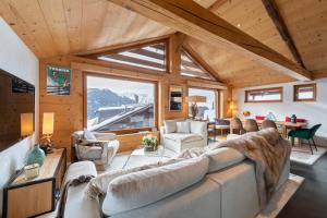 a living room with a large couch and a large window at Luxurious Chalet in Verbier in Verbier