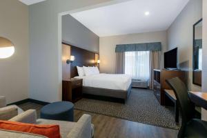 a hotel room with a bed and a television at Wingate by Wyndham - DFW North in Irving