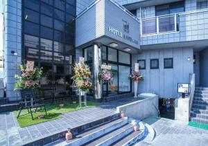 a building with a flower market in front of it at HOTEL LiVEMAX BUDGET Gunma Numata in Numata