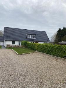 a house with a black roof and a gravel driveway at FerienanlageKappeln in Kappeln