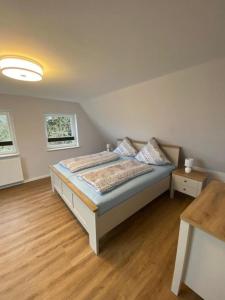 een slaapkamer met een bed en een houten vloer bij FerienanlageKappeln in Kappeln