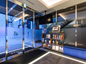 HOTEL LiVEMAX Akasaka في طوكيو: غرفة مع تلفزيون ورف كتاب