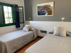 une chambre avec deux lits et un tableau au mur dans l'établissement Relax Tiñosa Apartment, à Puerto del Carmen