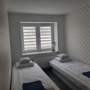twee bedden in een kamer met een raam bij Willa Aster in Rewa