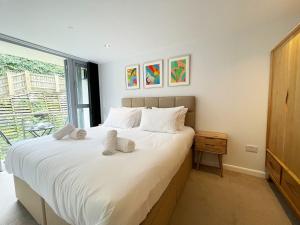 a bedroom with a large white bed and a window at 8 Zinc in Newquay