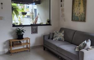 sala de estar con sofá y ventana en CASA AZUL São Pedro en São Pedro