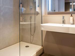 y baño con ducha y lavamanos. en Mercure Grenoble Meylan, en Meylan