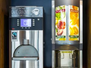 a drink vending machine next to a box of orange juice at ibis budget Montauban Les Chaumes in Montauban