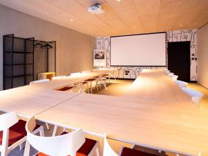 een klaslokaal met tafels en stoelen en een whiteboard bij ibis budget Montauban Les Chaumes in Montauban