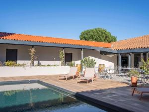 a house with a swimming pool and chairs next to a house at ibis budget Montauban Les Chaumes in Montauban