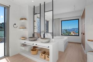 a white bathroom with a sink and a mirror at Villa Eureka BY APOKORONAS-VILLAS in Plaka +66 photos