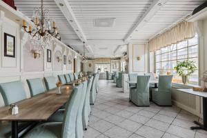 Best Western Hotel Statt Katrineholm في كاترنيهولم: غرفة طعام مع طاولة وكراسي طويلة