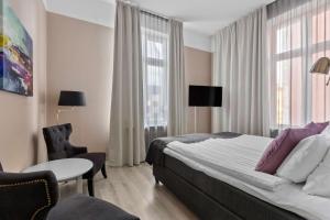 カトリーネホルムにあるBest Western Hotel Statt Katrineholmのベッド、テーブル、椅子が備わるホテルルームです。
