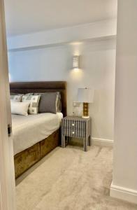 um quarto com uma cama e uma mesa com um candeeiro em Sofias Flat em Bournemouth