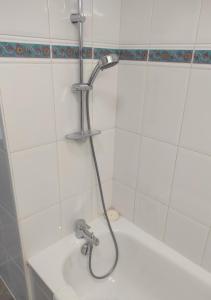 um chuveiro numa casa de banho em azulejos brancos em Studio avec terrasse proche des transports. em Issy-les-Moulineaux