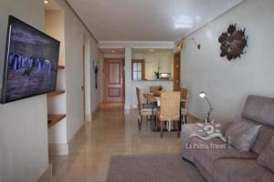 a living room with a couch and a dining room at Apartamento de dos dormitorios con Wifi y frente a playa en Puerto de Tazacorte in Tazacorte