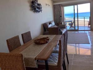 un comedor con mesa y sillas y el océano en Apartamento de dos dormitorios con Wifi y frente a playa en Puerto de Tazacorte en Tazacorte