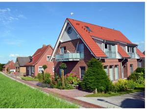 una gran casa de ladrillo con techo naranja en Dieknüst, en Greetsiel