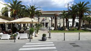 a courtyard with chairs and umbrellas and palm trees at Pratza Froria in Villasimius