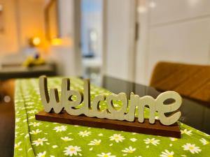 a wooden sign that says welcome on a table at Sofias Flat in Bournemouth