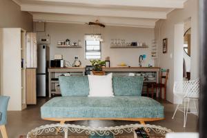 a living room with a couch and a kitchen at Into the Mystic in Paternoster