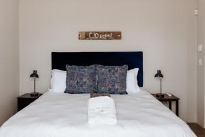 a bedroom with a white bed with two night stands at Into the Mystic in Paternoster