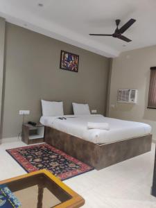 1 dormitorio con 1 cama grande y ventilador de techo en Hotel Sukhdham, en Allahābād