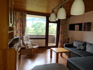a living room with a couch and a large window at BFE Schwarzwaldidylle in Baiersbronn