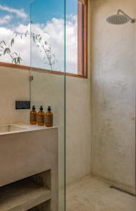 a glass shower in a bathroom with a fireplace at The Hotel in Ahangama