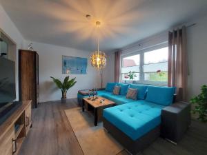 a living room with a blue couch and a table at Ferienhaus Hinrichs 