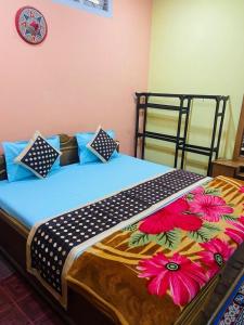 1 Schlafzimmer mit einem Bett mit Blumenbettdecke in der Unterkunft TG Resort in Nāmdāng