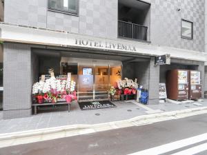 un magasin à l'avant d'un bâtiment présentant des fleurs dans l'établissement HOTEL LiVEMAX Tokyo Shintomicho, à Tokyo