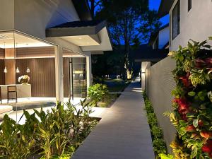 a walkway leading to a house with plants at Looma Private Pool Villas in Pantai Cenang