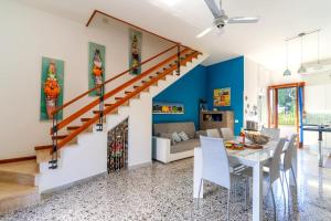 una sala da pranzo e un soggiorno con pareti blu e scala di Villa Marea a Nardò