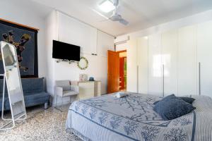 1 dormitorio con 1 cama, TV y silla en Villa Marea, en Nardò