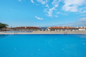 une grande piscine bleue avec des chaises et un bâtiment dans l'établissement Villa View Candesol, à Santiago del Teide