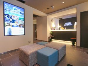 HOTEL LiVEMAX Tokyo Shintomicho في طوكيو: غرفة بسرير وشاشة كبيرة على الحائط