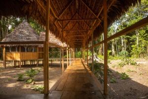 Eywa Lodge Amazonas - All inclusive في Yucuruche: جناح الخيزران كبير مع سقف من القش