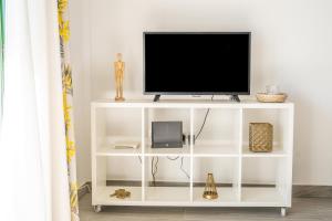 a white entertainment center with a television on top at New & Renovated Vacation Apartment in Costa de Antigua