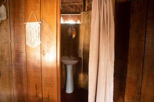 a bathroom with a toilet and a curtain at Eywa Lodge Amazonas - All inclusive in Yucuruche