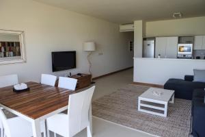 a living room with a dining room table and a couch at Cap Ouest Luxury Beachfront in Flic-en-Flac