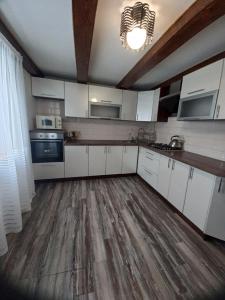 a kitchen with white cabinets and a wooden floor at White House in Slavske