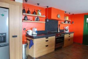 a kitchen with orange walls and a black counter top at Villa Madras in Pointe-Noire