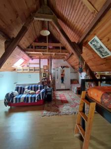 ein Wohnzimmer mit einer Couch und einem Bett in der Unterkunft Magnifique Moulin au bord d'une riviere, calme absolu, piano in Doyet