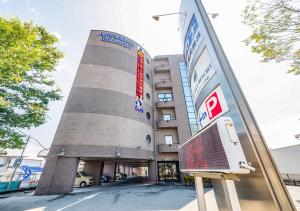 a building with a sign in front of it at HOTEL LiVEMAX Kofu in Kai