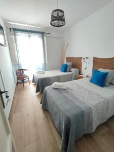Duas camas num quarto com almofadas azuis em Tirwal Suite em Teruel